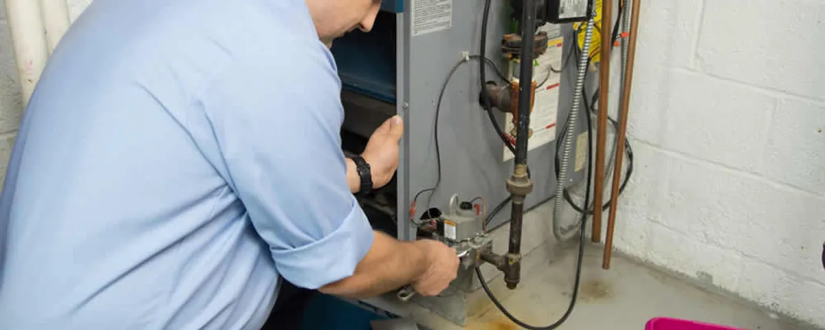 Furnace repair technician inspecting and servicing a home heating system in Albuquerque, NM