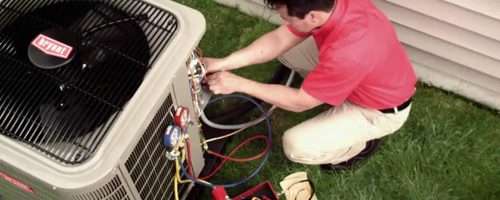 HVAC technician servicing an outdoor air conditioner unit in Albuquerque, NM