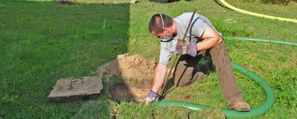 Septic pumping technician servicing a residential septic tank in Albuquerque, NM